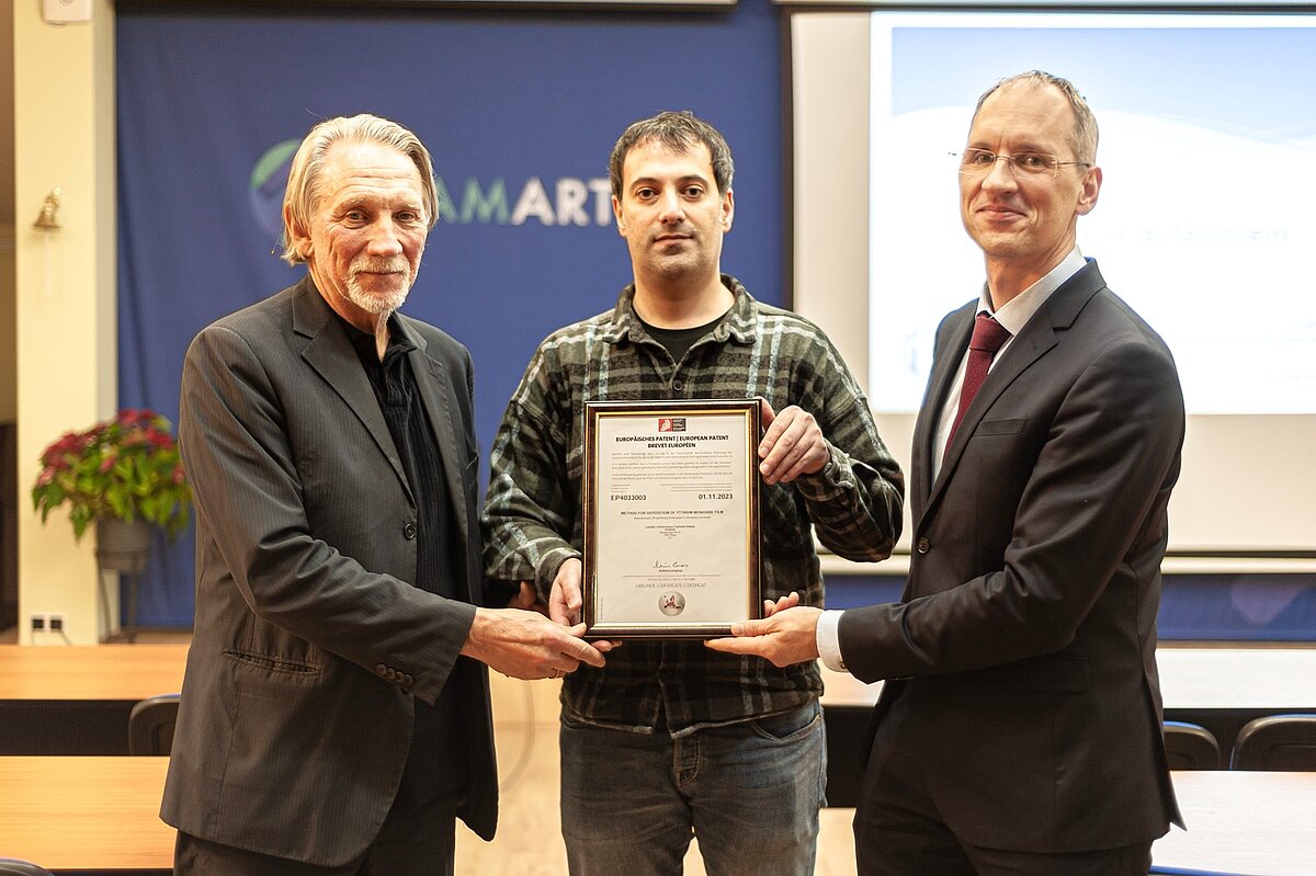 Photo (from the left side): ISSP UL's Head of Thin Films Laboratory Juris Purāns, Scientific Assistant of the laboratory Halil Arslan and the partner of patent office "FORAL" Jevgeņijs Fortūna with the issued patent